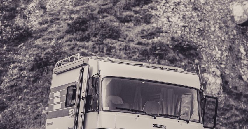 RV Routes - A black and white photo of a camper van parked on a hill