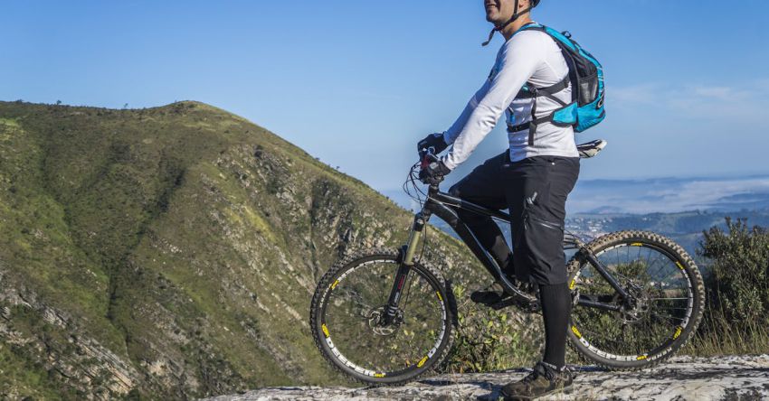 Cycling Trip - Man With White Shirt Riding Abicycle on a Mountain