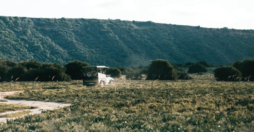 ATV Trip - ATV driving on road against green mountain in savanna